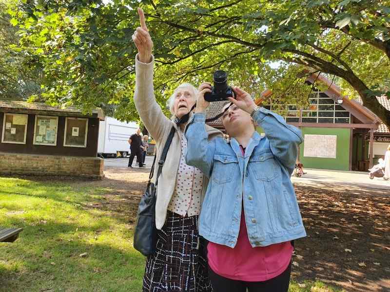 resident and carer out in the local park taking photos of wildlife