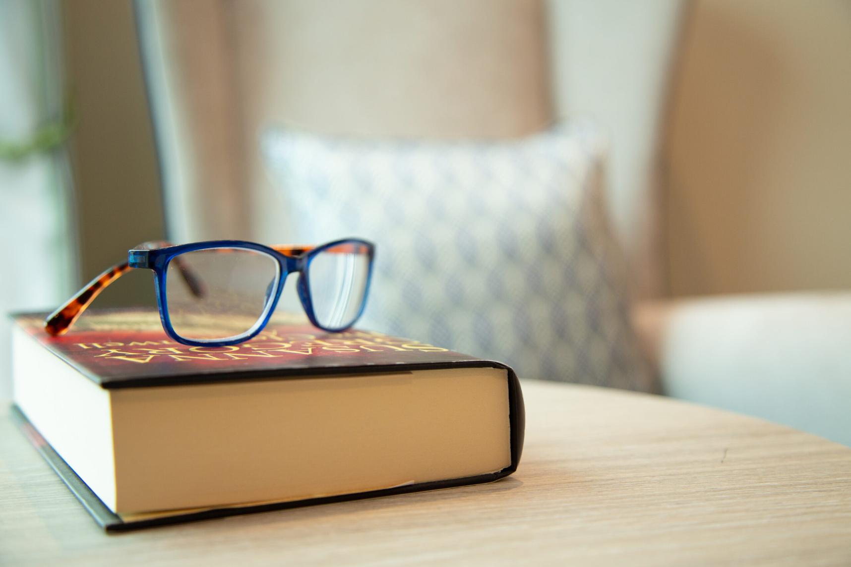 glasses on top of a book on a side table