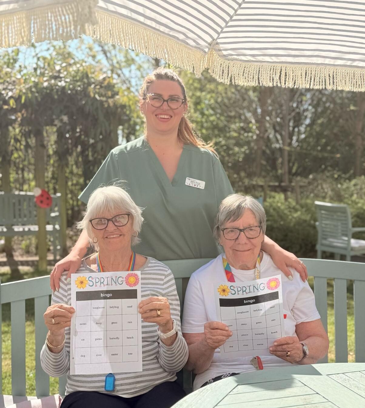 team member smiling with residents doing garden bingo