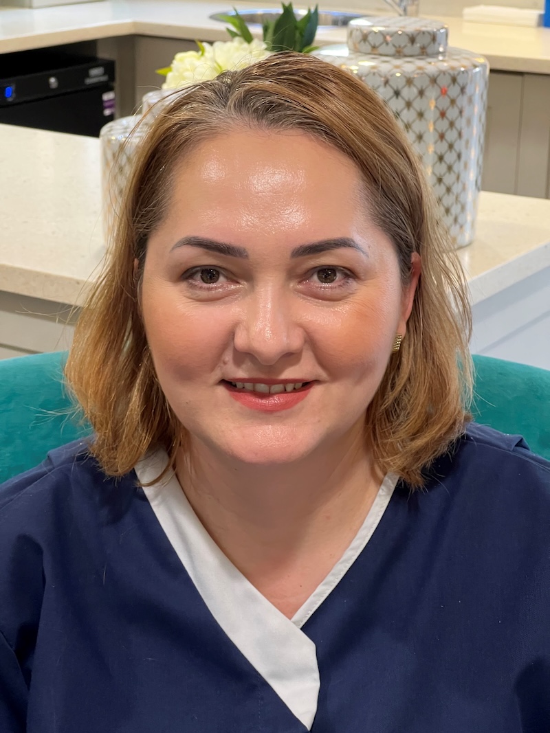 Elena one of our nurses sat in an armchair wearing a blue nurse uniform