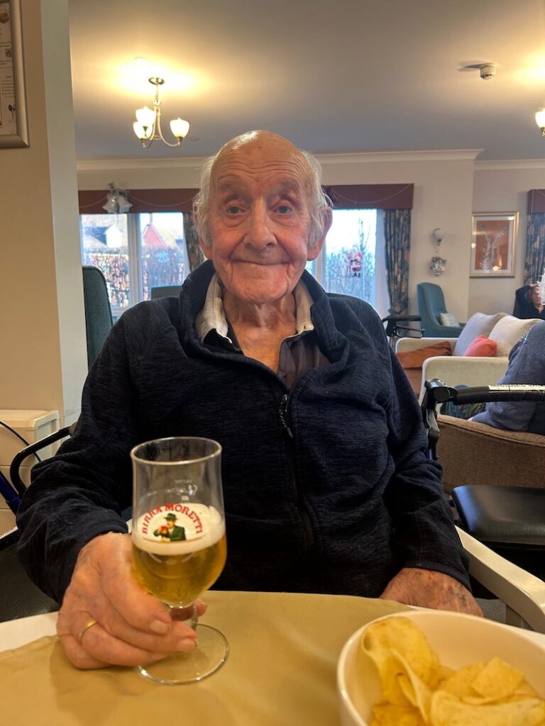one of our male residents sat smiling with a moretti beer in his hand