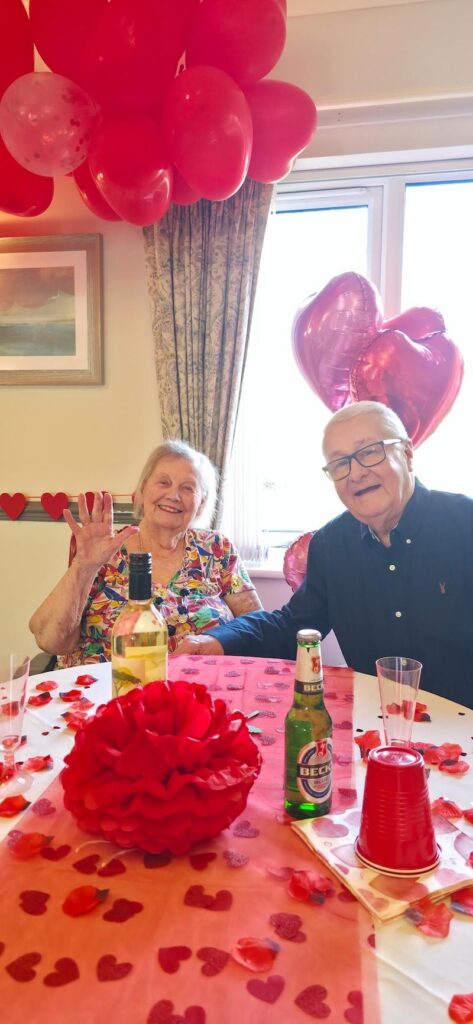 older man and woman sat together at the table enjoying a valentines themed lunch