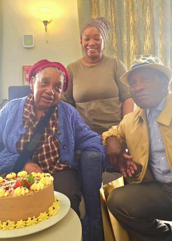 one of our residents meg sat in the lounge smiling with her family on her birthday