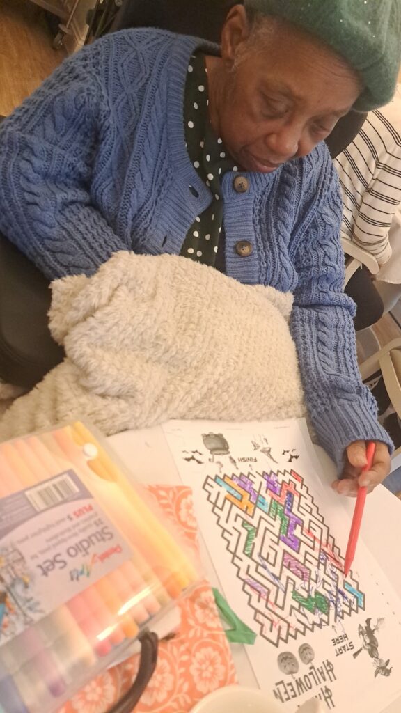 female resident sat down doing colouring