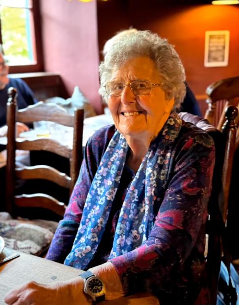 older lady smiling while sat at the table
