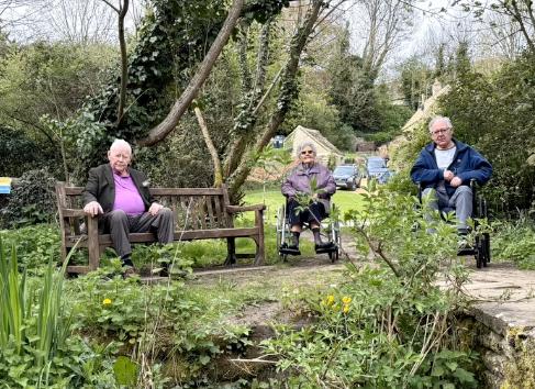 three older adults sat in a park