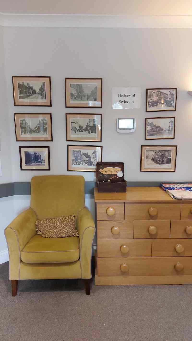 a yellow armchair and historical framed pictures on the wall