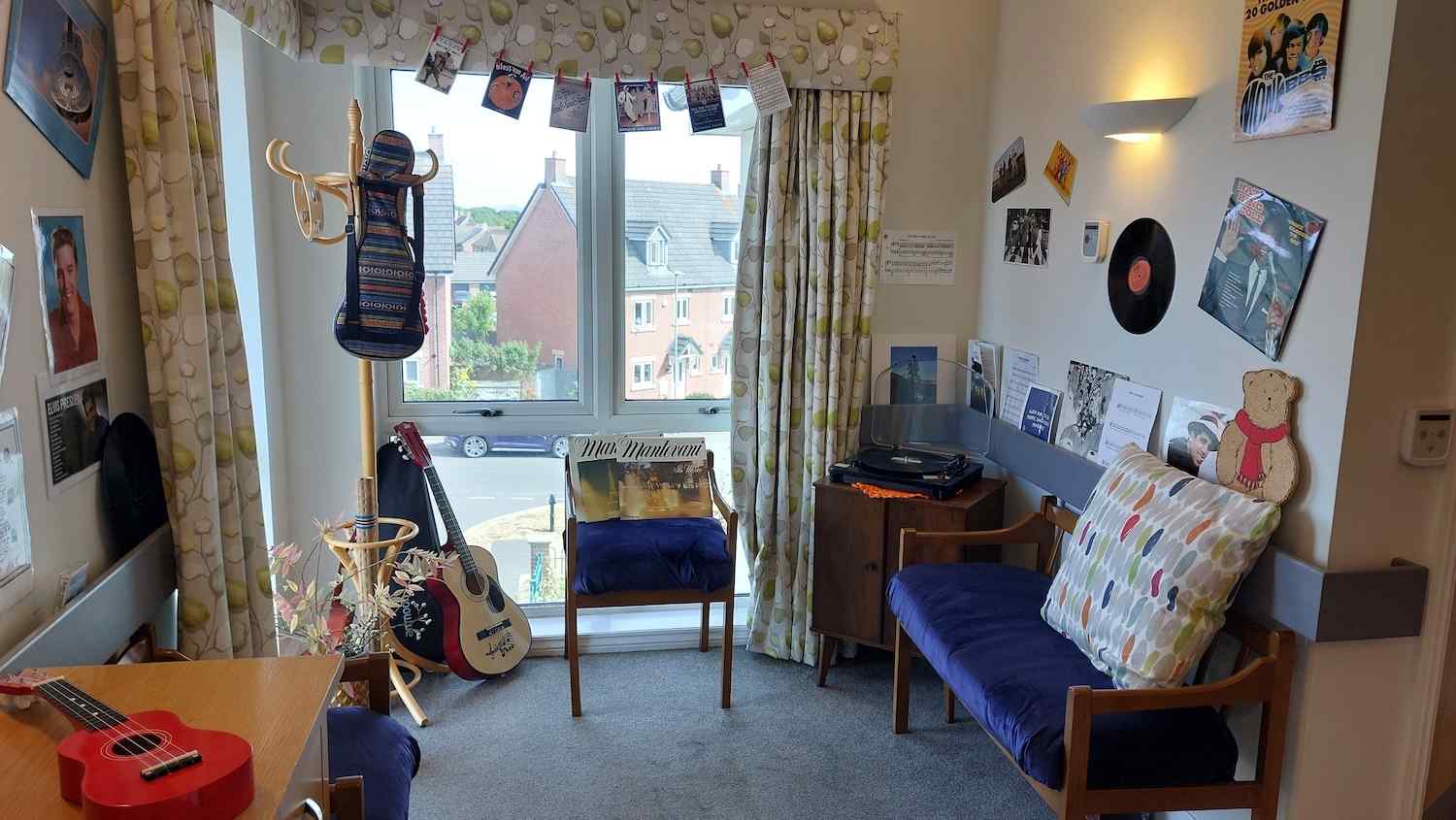 our music destination point with an armchair, record player and instruments up on the wall