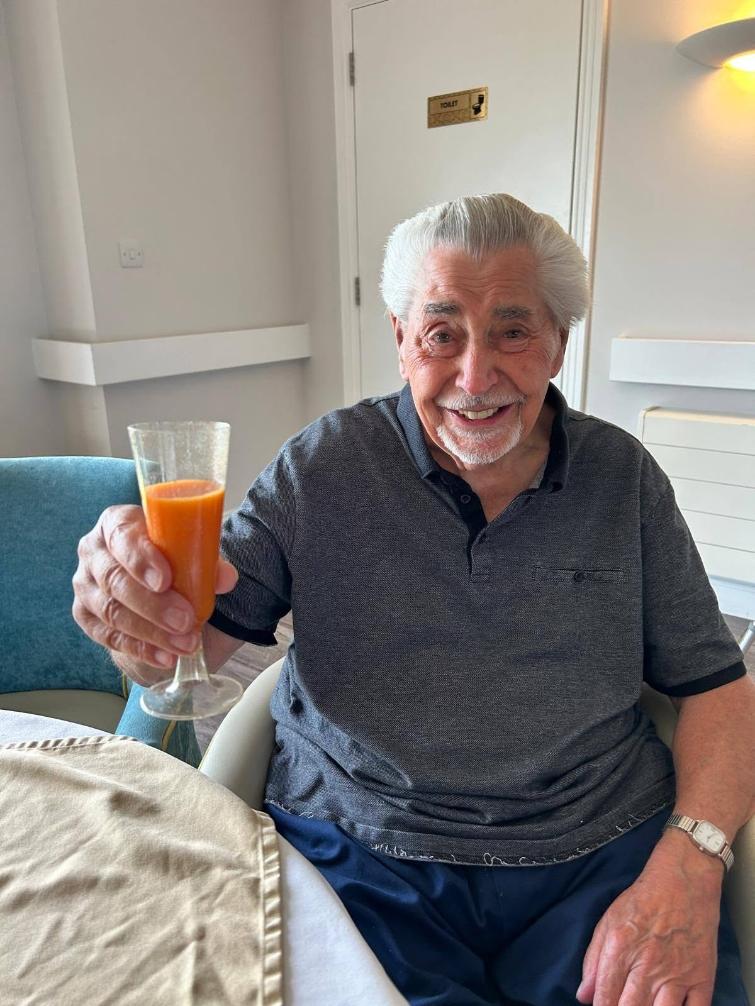 older man holding drink