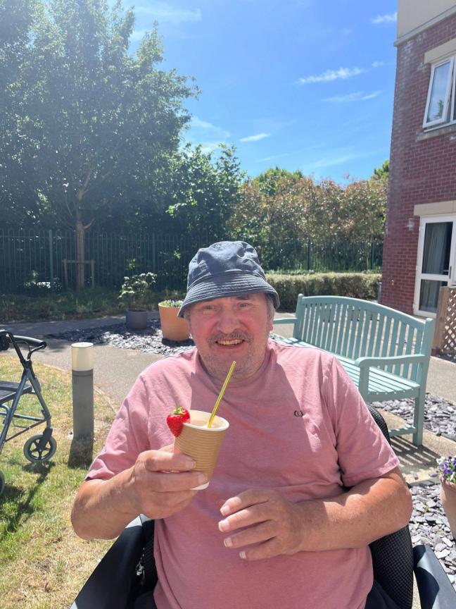 older man holding drink