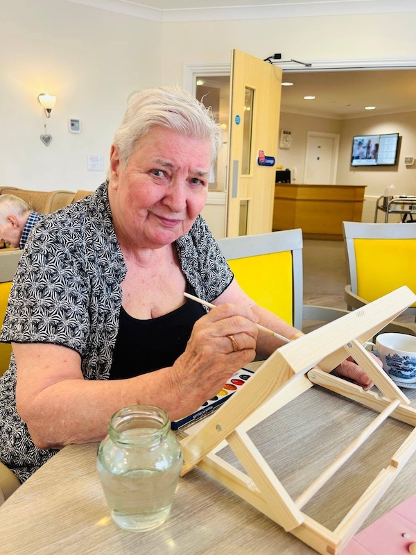resident painting and smiling